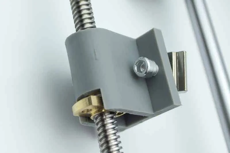 The brass nut on the lead screw in its grey holder