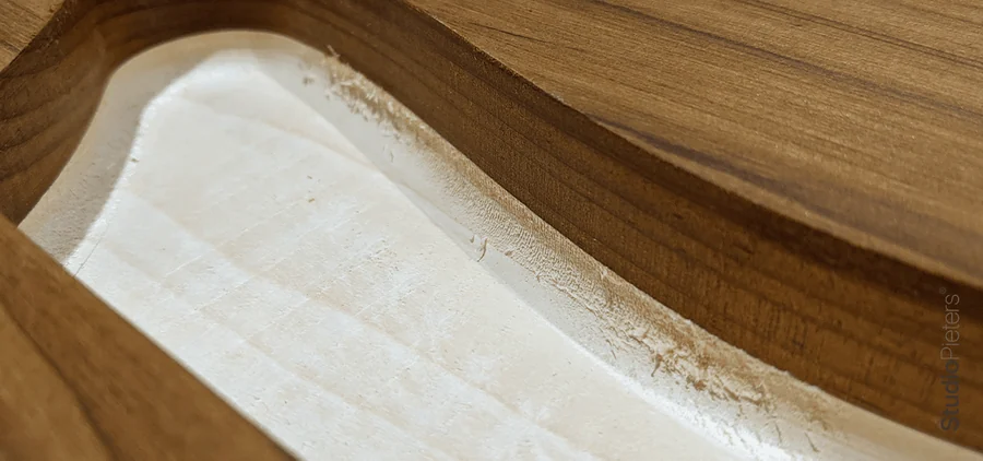 A smooth curved cut in wood made with a ball nose bit