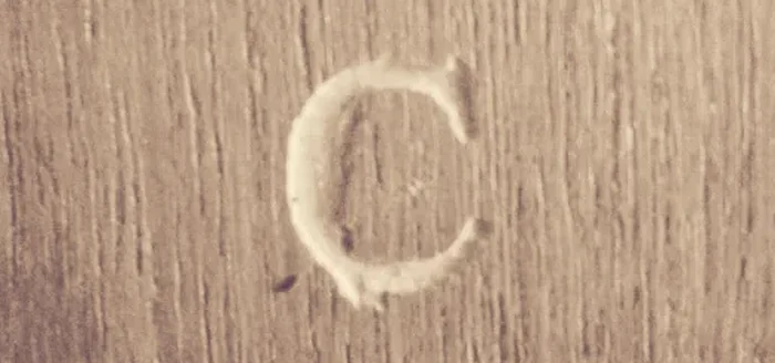 The letter C engraved in wood