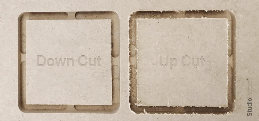 Two squares cut in wood, one with a down cut bit and one with an up cut bit