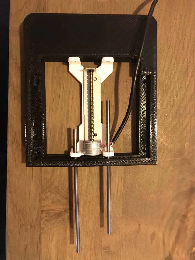 The black frame with the rods and the slider inside