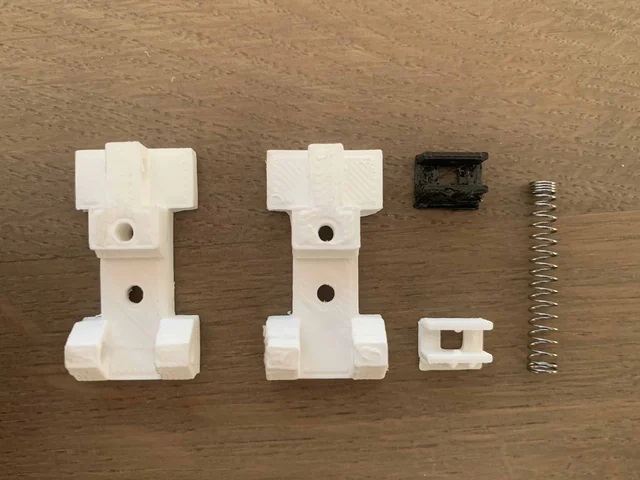 Printed white slider parts, a spring and a small holder